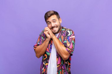 Genç adam aşık ve sevimli görünüyor. Sevimli ve mutlu. Romantik bir şekilde gülümsüyor.