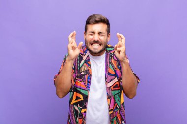 Genç adam gergin ve umutlu, şans diliyor ve dua ediyor.