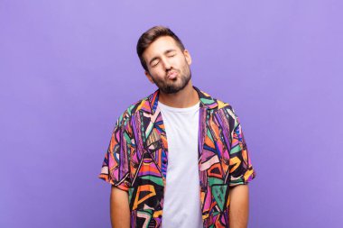 Genç adam dudaklarını birbirine bastırıyor, tatlı, eğlenceli, mutlu, sevimli bir yüz ifadesiyle, öpücük yolluyor.