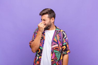 Delikanlı iğreniyor, pis ve nahoş bir koku duymamak için burnunu tutuyor.