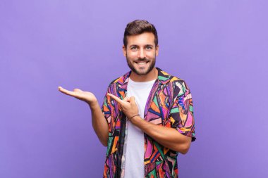 Genç adam neşeyle gülümsüyor ve bir objeyi göstererek veya reklamını yaparak avucundaki kopyalama alanını işaret ediyor.