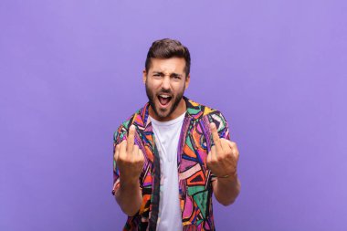 Genç adam kışkırtıcı, agresif ve müstehcen hissediyor. İsyankar bir tavırla orta parmağını hareket ettiriyor.