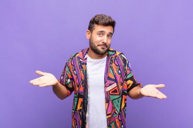 Genç adam şaşkın ve şaşkın hissediyor, doğru cevap veya karardan emin değil, bir seçim yapmaya çalışıyor.