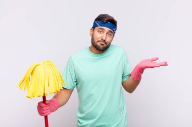 Genç adam şaşkın ve şaşkın hissediyor, şüpheci, farklı seçenekleri tartıyor veya komik bir ifadeyle seçiyor.