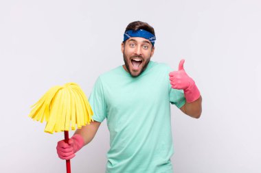 Genç adam mutlu, şaşkın, tatmin olmuş ve şaşırmış hissediyor, iyi görünüyor ve el hareketlerini gösteriyor, gülümsüyor.