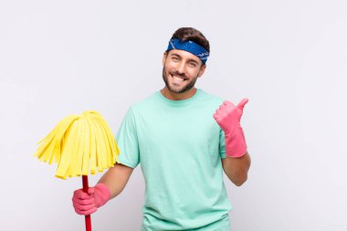 Genç adam neşeyle gülümsüyor ve mutlu görünüyor, kaygısız ve pozitif hissediyor.