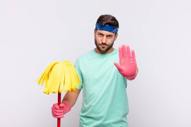 Genç adam ciddi, sert, kızgın ve hoşnutsuz görünüyor.