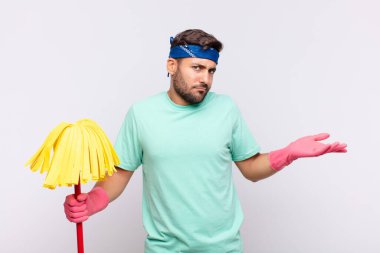 Genç adam şaşkın, şaşkın ve stresli görünüyor, farklı seçenekler arasında merak ediyor, kararsız hissediyor.