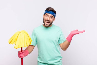 Genç adam gülümsüyor, kendinden emin, başarılı ve mutlu, fotokopi alanında fikir veya konsept gösteriyor.