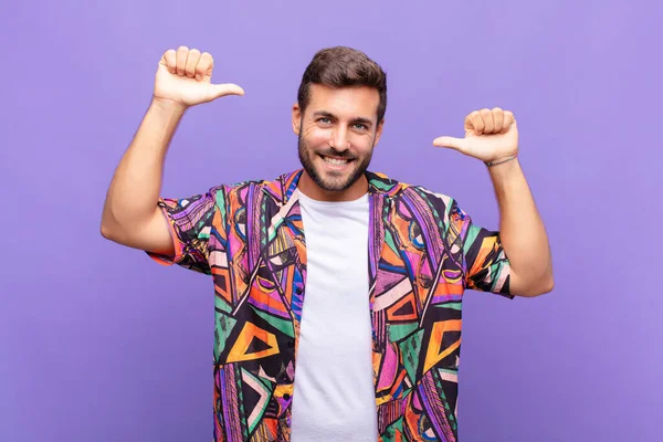 Genç adam gururlu, kibirli ve kendinden emin, tatmin olmuş ve başarılı görünüyor, kendini işaret ediyor.