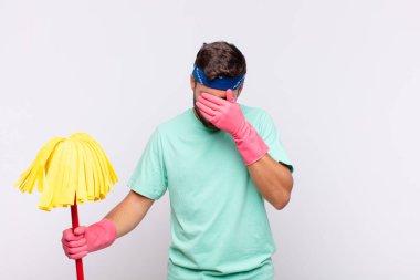 Genç adam üzgün, hayal kırıklığına uğramış, gergin ve depresif, iki eliyle yüzünü kaplayan, ağlayan