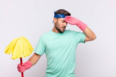 Genç adam stresli, yorgun ve hayal kırıklığına uğramış görünüyor, alnından ter damlıyor, umutsuz ve bitkin hissediyor.