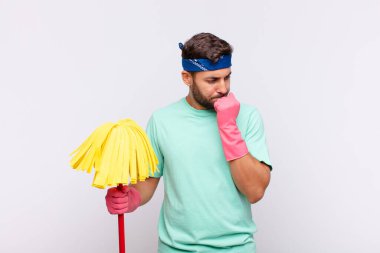 Genç adam ciddi, düşünceli ve endişeli, elleri çenesine bastırılmış, yan bakıyor