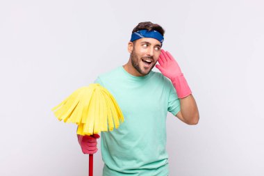 Genç adam gülümsüyor, tuhaf bir şekilde yan tarafa bakıyor, dedikoduları dinlemeye ya da bir sırrı duymaya çalışıyor.