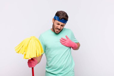 Genç adam üzgün, yaralı ve kalbi kırık görünüyor, iki elini de kalbe yakın tutuyor, ağlıyor ve bunalımda.