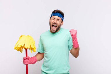 Genç adam son derece mutlu ve şaşırmış görünüyor, başarıyı kutluyor, bağırıyor ve zıplıyor.