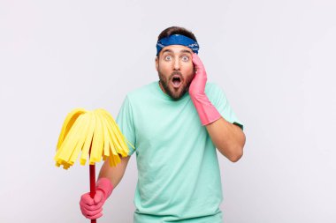 Genç adam mutsuz, korkmuş ya da endişeli görünüyor, ağzı sonuna kadar açık ve iki kulağını da elleriyle kapatıyor.