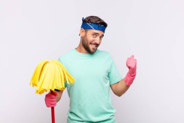 Genç adam neşeyle gülümsüyor ve yan taraftaki fotokopi alanını gösteriyor, mutlu ve tatmin olmuş hissediyor.