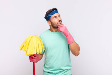 Genç adam düşünceli, meraklı ya da hayal kuruyor, hayal kuruyor ve uzayı kopyalamak için yukarı bakıyor.