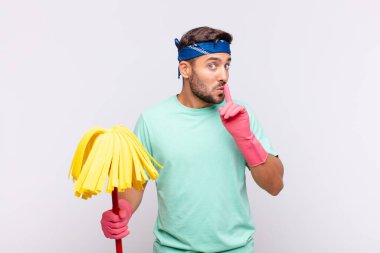 Genç adam sessizlik ve sessizlik istiyor, parmaklarıyla ağzının önünde işaret ediyor, 