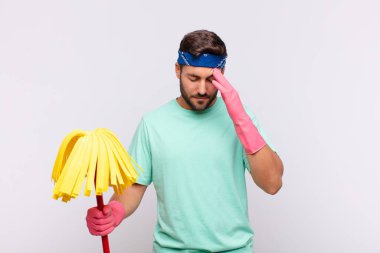 Genç adam stresli ve hayal kırıklığına uğramış görünüyor, baskı altında çalışıyor, başı ağrıyor ve sorunlarla boğuşuyor.