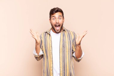 Genç adam mutlu, heyecanlı, şaşırmış ya da şaşırmış hissediyor. İnanılmaz bir şeye gülümsüyor ve şaşırıyor.