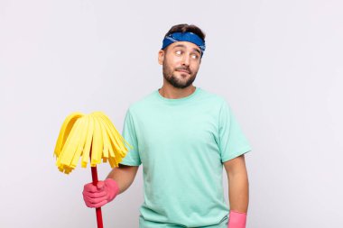 Genç adam merak ediyor, mutlu düşünceler ve fikirler düşünüyor, hayal kuruyor, kenarda yer arıyor.