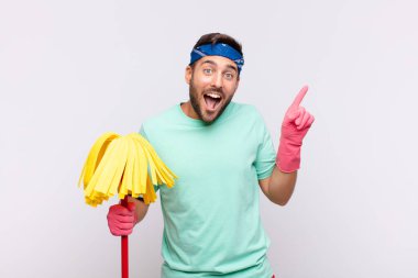 Genç adam sevinçli ve şaşırmış hissediyor, şok olmuş bir ifadeyle gülümsüyor ve bir tarafı işaret ediyor.