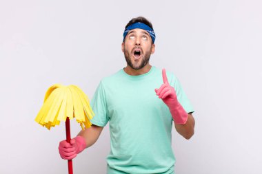 Genç adam şaşırmış, şaşırmış ve ağzı açık bir şekilde iki eliyle uzayı göstererek uzayı kopyalıyor.