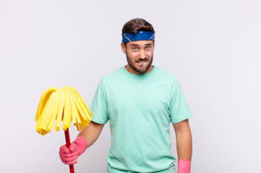 Genç adam şaşkın ve şaşkın görünüyor, gergin bir hareketle dudağını ısırıyor, sorunun cevabını bilmiyor.