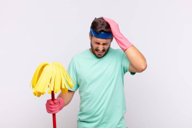 Genç adam kendini stresli ve hayal kırıklığına uğramış hissediyor, ellerinizi havaya kaldırıyor, yorgun, mutsuz ve migren ağrısı çekiyor.