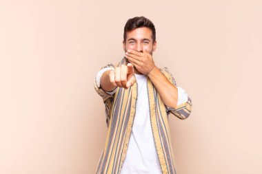 Genç adam sana gülüyor, kamerayı işaret ediyor ve seninle dalga geçiyor ya da alay ediyor.