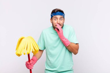 Genç adam mutlu ve heyecanlı, şaşırmış ve şaşırmış elleriyle ağzını kapatmış, tatlı bir ifadeyle kıkırdıyor.