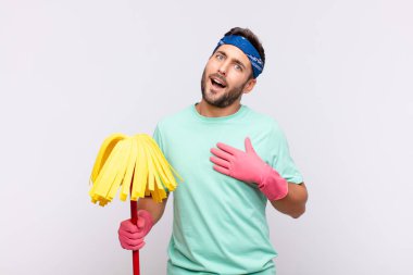 Genç adam mutlu ve aşık, bir eli kalbinin yanında, diğer eli önde uzanmış gülümsüyor.