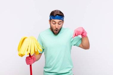 Genç adam şok olmuş, ağzı açık ve şaşkın, inançsızlık ve şaşkınlık içinde bakıyor ve onu işaret ediyor.