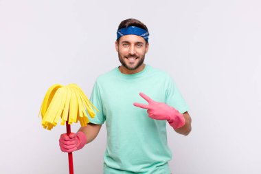 Genç adam mutlu, pozitif ve başarılı hissediyor, göğsünün üzerinde el yapımı V ile zafer ya da barış gösteriyor.