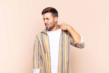 Genç adam stresli, endişeli, yorgun ve hayal kırıklığına uğramış, gömleğini çekmiş, sorunlu görünüyor.