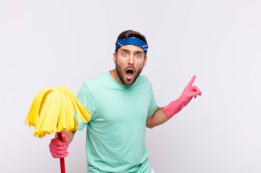 Delikanlı şaşkın ve şaşırmış hissediyor. Kenardaki fotokopi alanını işaret ediyor. Şaşırmış ve ağzı açık bakıyor.