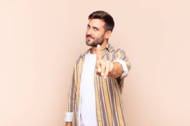 Genç adam gururla gülümsüyor ve gururla bir numaralı pozunu veriyor, kendini lider gibi hissediyor.