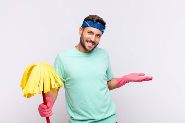 Delikanlı iki eli yanda olan bir objeyi tutuyor fotokopi alanı, bir nesneyi gösteriyor, sunuyor ya da reklamını yapıyor.