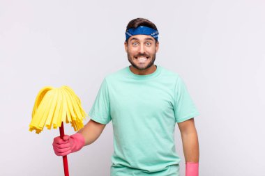 Genç adam mutlu ve şapşal görünüyor. Geniş, eğlenceli, deli gülüşü ve gözleri açık.