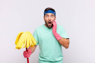 Genç adam şok olmuş ve korkmuş hissediyor, ağzı açık ve elleri yanaklarında korkmuş görünüyor.