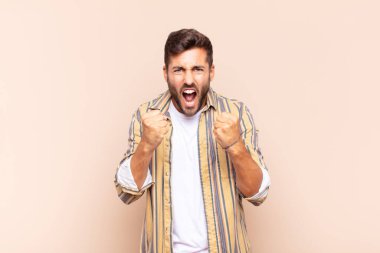 Delikanlı sinirli sinirli, sinirli bakışlar ve yumruklarla bağırıyor. Öfkeli hissediyor.