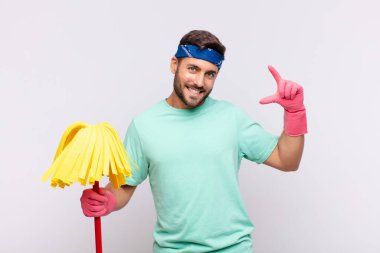 Genç adam kendi gülüşünü iki eliyle çiziyor, olumlu ve mutlu görünüyor, sağIık kavramı