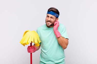 Genç adam sinirli, stresli ve sinirli görünüyor, iki kulağını da sağır edici bir ses, ses ya da yüksek sesle kapatıyor.