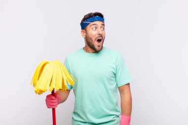 Genç adam şaşkın, mutlu, şaşkın ve şaşırmış hissediyor, ağzı açık bir şekilde yana bakıyor.