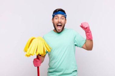 Genç adam muzaffer bir şekilde bağırıyor, heyecanlı, mutlu ve şaşırmış görünüyor.