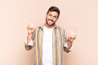 Genç adam gülümsüyor ve mutlu görünüyor, arkadaş canlısı ve tatmin olmuş, zafer ya da barış simgesi.