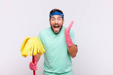 Genç adam beklenmedik bir sürprizden dolayı şaşkın, heyecanlı, gülen, şaşkın ve mutlu hissediyor.