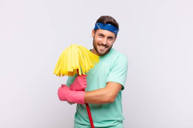 Genç adam sevinçle gülümsüyor ve kutluyor, yumruklarını sıkmış ve kollarını kavuşturmuş, mutlu ve pozitif hissediyor.